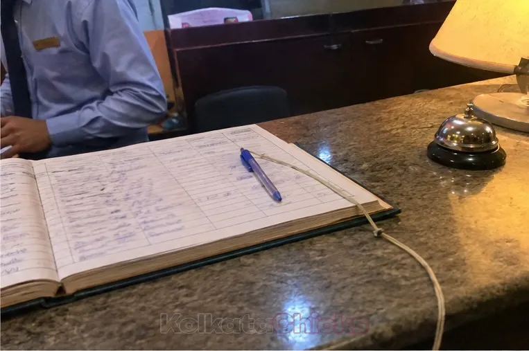 A visitor register and pen on a hotel front desk in Kolkata