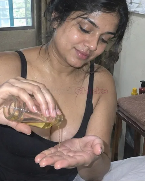 Massage girl pouring oil into her palm in a Kolkata room