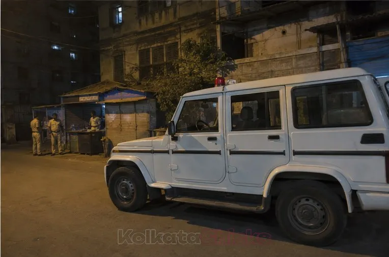 A police patrol van parked on an old Kolkata street at night