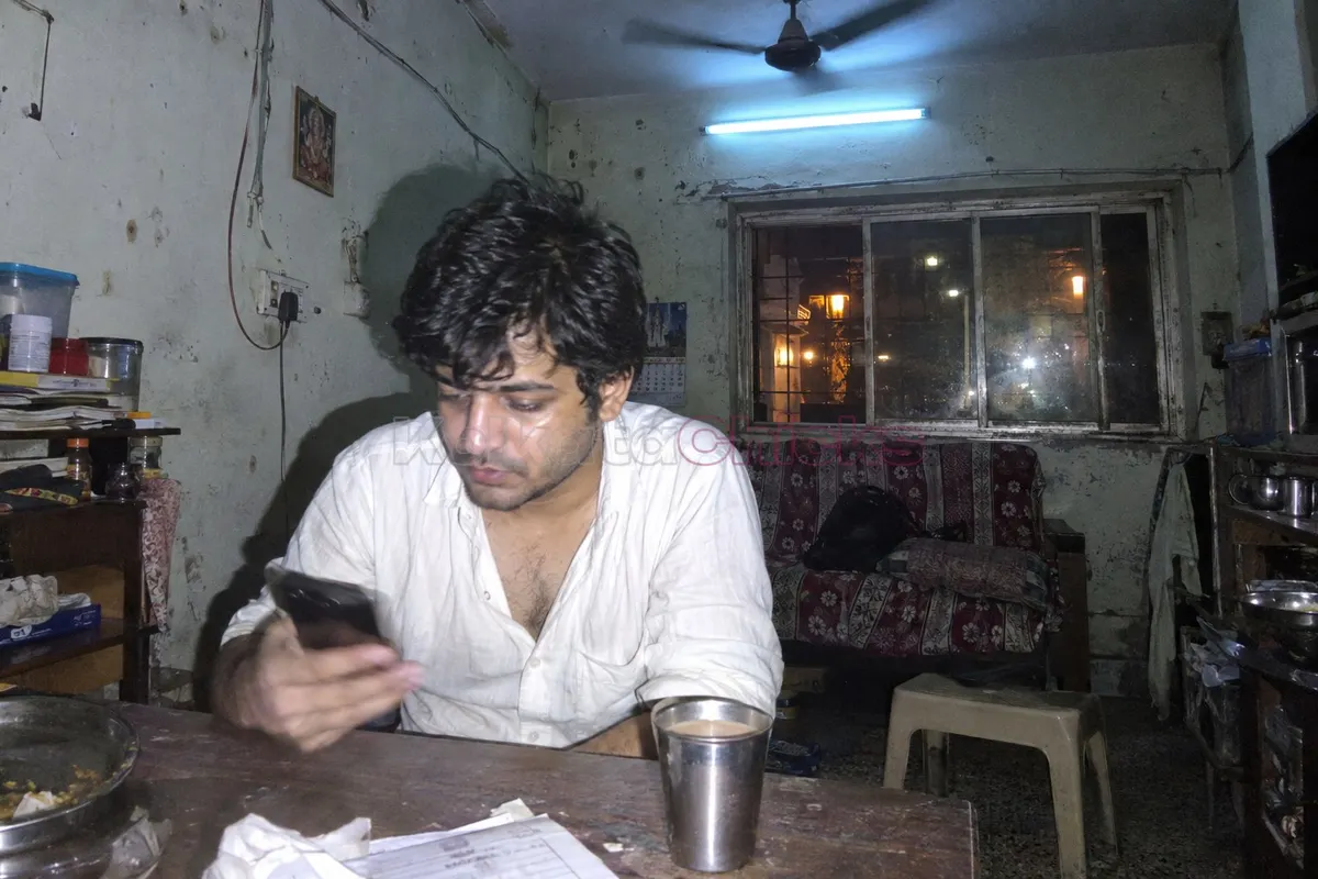 Man in Kolkata reading a call girl advert on his phone late at night
