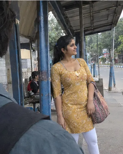 Kolkata escort in a yellow kurti waiting at a bus stop