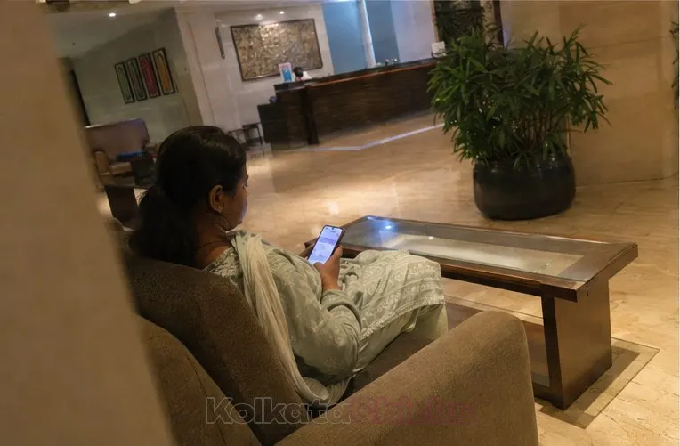 A woman in a salwar suit waiting on a hotel lobby sofa in Kolkata